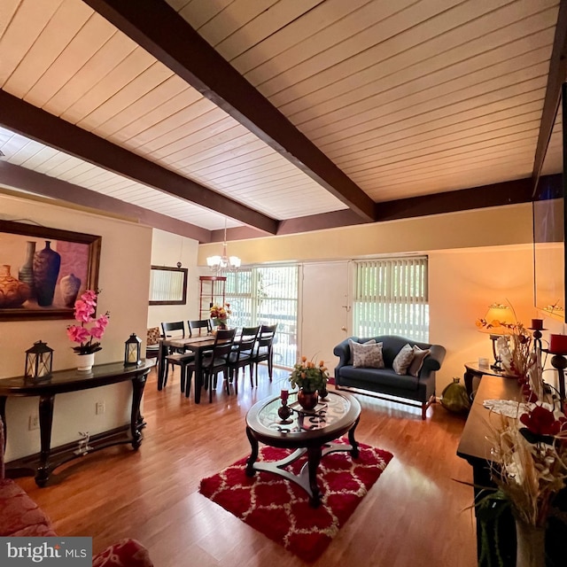 living area with beamed ceiling, wood finished floors, a chandelier, and wood ceiling