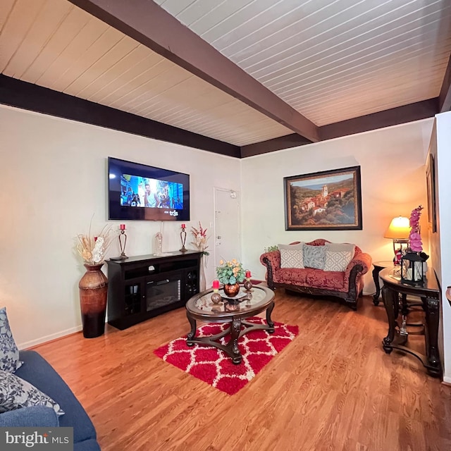 living room with beamed ceiling, wood finished floors, and baseboards