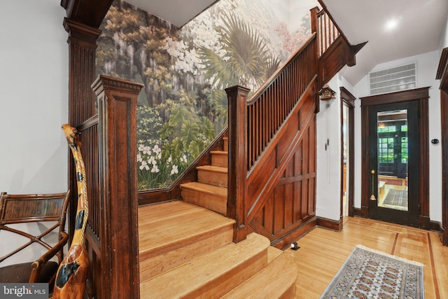 stairway with baseboards, lofted ceiling, and wood finished floors