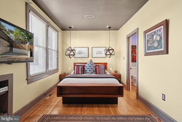 bedroom featuring light wood-type flooring, baseboards, and visible vents