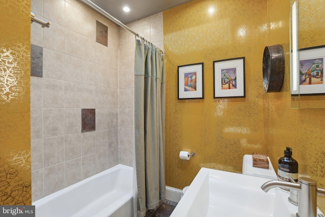 bathroom featuring recessed lighting, a sink, baseboards, and shower / tub combo with curtain