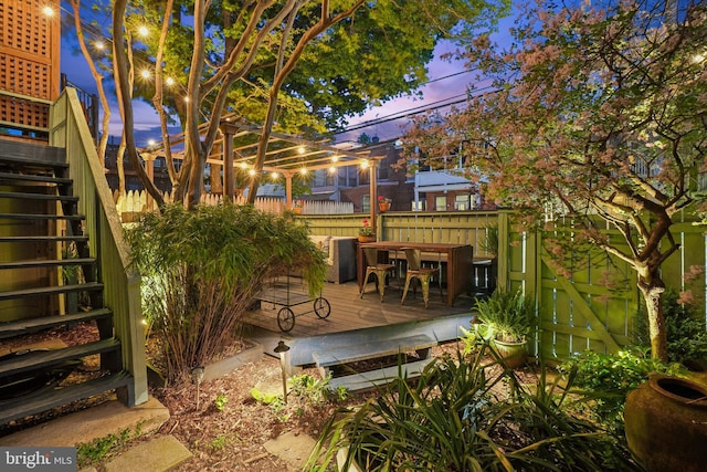 view of patio / terrace with a deck, fence, stairs, and outdoor dining space
