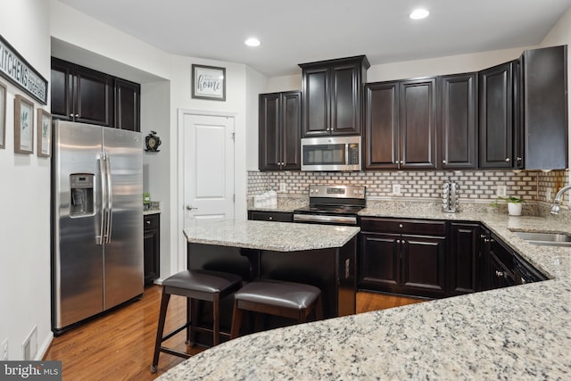 155 Tollerton Trl, Falling Waters, WV 25419 - kitchen featuring stainless steel appliances, a sink, backsplash, light stone countertops, and a breakfast bar
