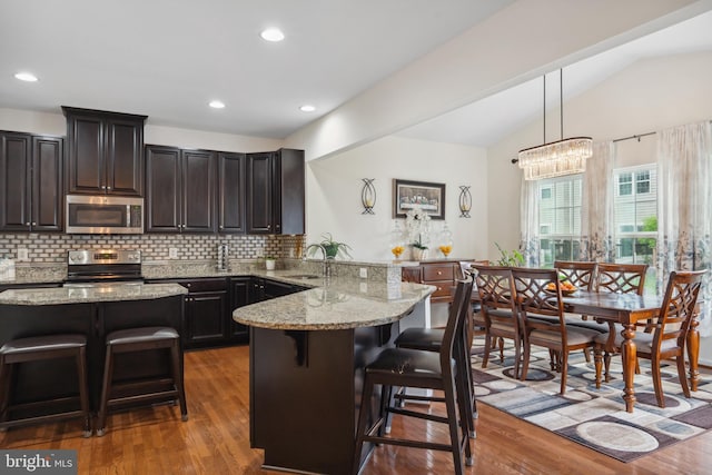 155 Tollerton Trl, Falling Waters, WV 25419 - kitchen with appliances with stainless steel finishes, a breakfast bar area, a peninsula, a sink, and vaulted ceiling