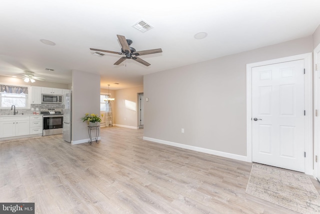 5 Greenmeadow Ln, Whiting, NJ 08759 - unfurnished living room with visible vents, baseboards, a sink, and ceiling fan with notable chandelier