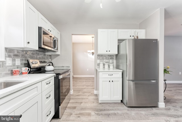 5 Greenmeadow Ln, Whiting, NJ 08759 - kitchen with light wood-style floors, stainless steel appliances, backsplash, baseboards, and white cabinetry