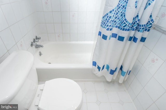 bathroom featuring toilet, tile walls, tile patterned flooring, and shower / tub combo with curtain