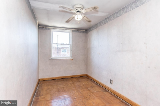 unfurnished room featuring a ceiling fan and baseboards