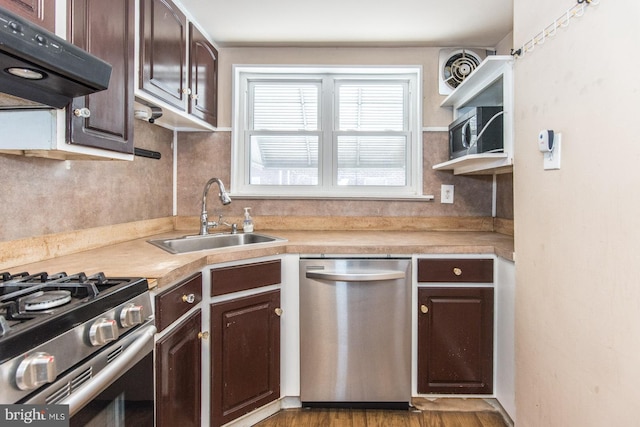kitchen with exhaust hood, appliances with stainless steel finishes, dark brown cabinets, a sink, and light countertops