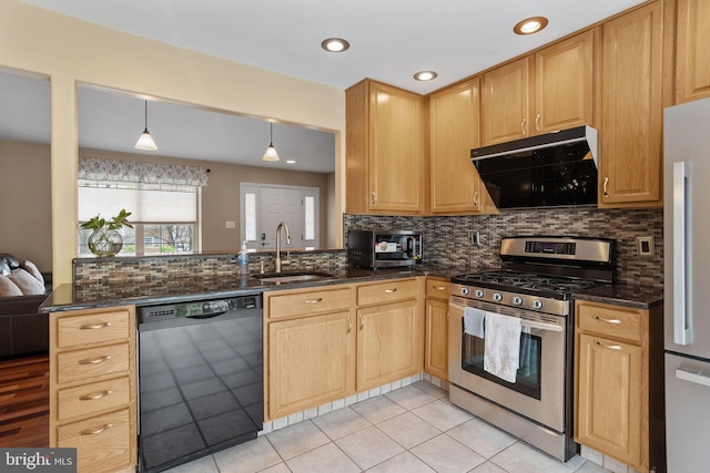 kitchen with appliances with stainless steel finishes, exhaust hood, dark stone countertops, and a sink