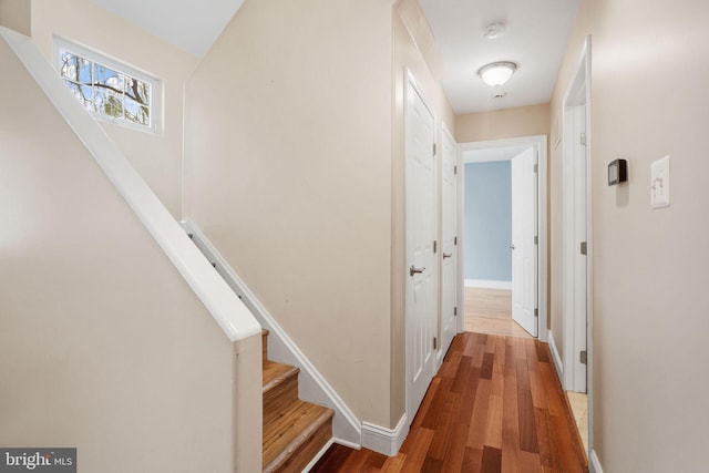 hall with wood finished floors, baseboards, and stairs