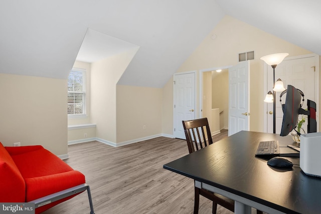office area featuring lofted ceiling, wood finished floors, visible vents, and baseboards
