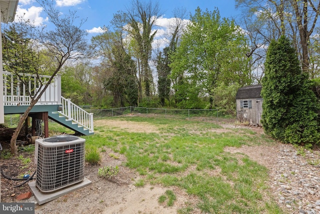 view of yard with an outdoor structure, stairs, a shed, central air condition unit, and fence