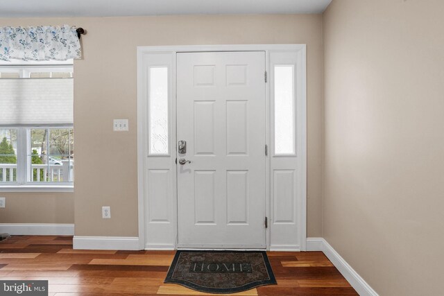 foyer with wood finished floors and baseboards