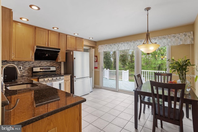 kitchen with exhaust hood, a sink, stainless steel appliances, light tile patterned flooring, and backsplash