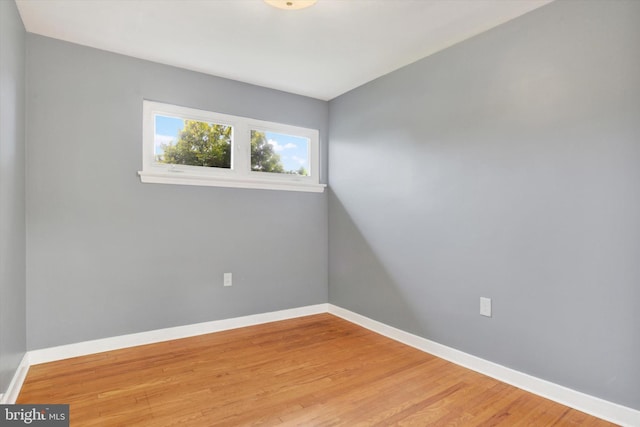 spare room featuring wood finished floors and baseboards