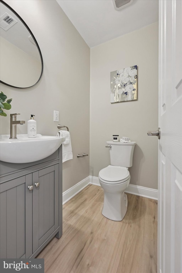 800 Erlen Rd, Plymouth Meeting, PA 19462 - half bathroom featuring vanity, toilet, baseboards, wood finished floors, and visible vents