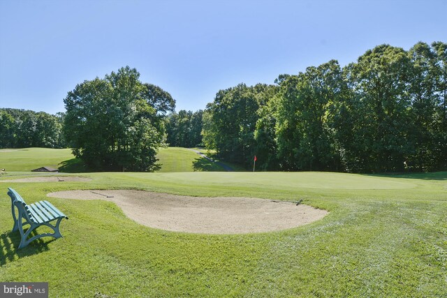 surrounding community featuring a yard and view of golf course