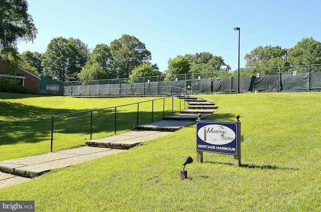 surrounding community with fence and a lawn