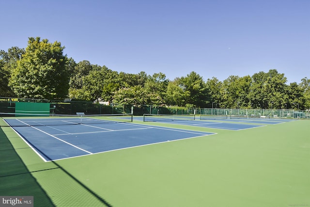 view of tennis court featuring fence and community basketball court
