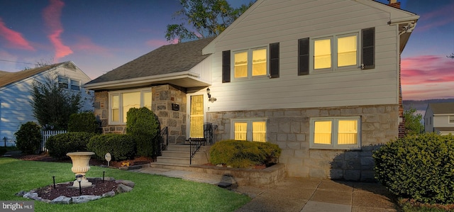 view of front of home featuring a chimney, stone siding, and a front lawn