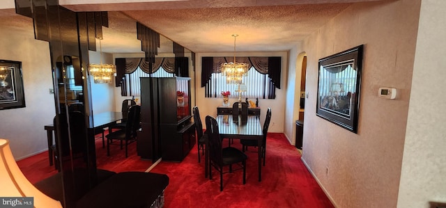 dining room with a textured ceiling, a textured wall, and a chandelier