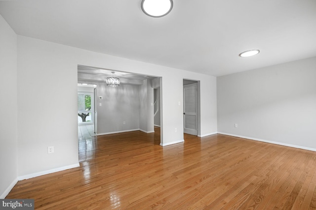 2456 Sun Valley Cir Unit 7-M, Silver Spring, MD 20906 - empty room with baseboards, wood-type flooring, and a notable chandelier