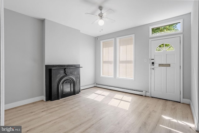 412 Market St, Trenton, NJ 08611 - unfurnished living room featuring wood finished floors, baseboard heating, ceiling fan, a fireplace, and baseboards