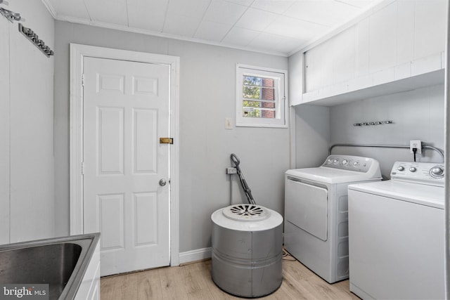 412 Market St, Trenton, NJ 08611 - laundry room featuring cabinet space, light wood finished floors, a sink, washing machine and dryer, and crown molding