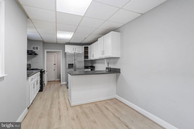 412 Market St, Trenton, NJ 08611 - kitchen with light wood-style flooring, open shelves, under cabinet range hood, white cabinets, and black gas stove