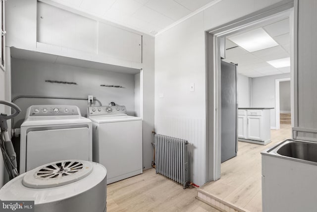 412 Market St, Trenton, NJ 08611 - clothes washing area with light wood-style flooring, radiator, washer and clothes dryer, ornamental molding, and laundry area