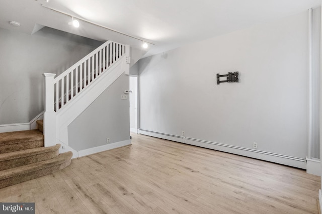 412 Market St, Trenton, NJ 08611 - unfurnished living room with stairway, a baseboard heating unit, baseboards, track lighting, and wood finished floors