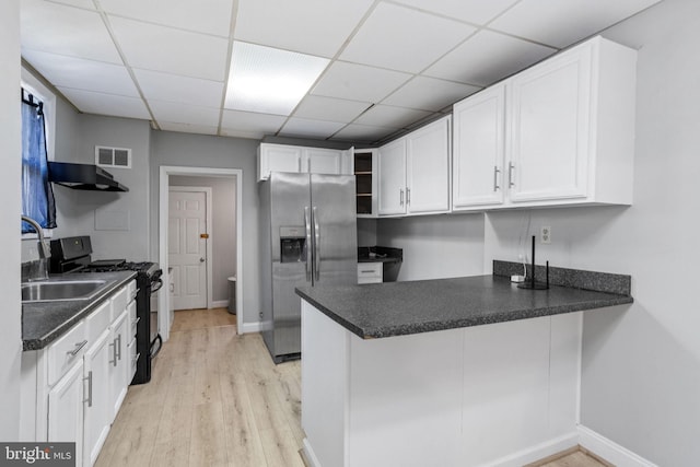 412 Market St, Trenton, NJ 08611 - kitchen with stainless steel fridge, open shelves, visible vents, a peninsula, and black range with gas cooktop