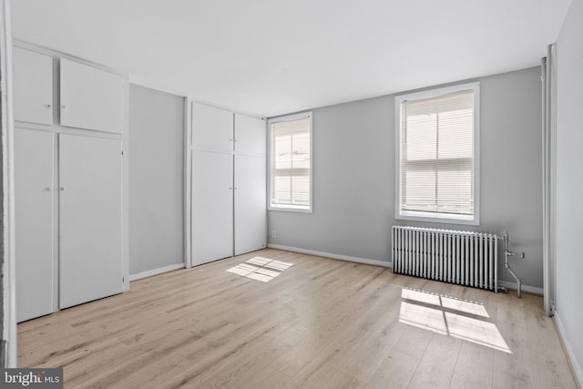 412 Market St, Trenton, NJ 08611 - unfurnished bedroom featuring baseboards, radiator heating unit, and light wood-type flooring