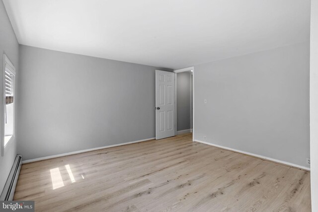 412 Market St, Trenton, NJ 08611 - unfurnished room featuring wood finished floors, a baseboard heating unit, and baseboards