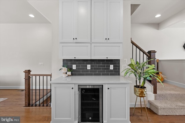 bar area with beverage cooler, baseboards, stairway, tasteful backsplash, and recessed lighting