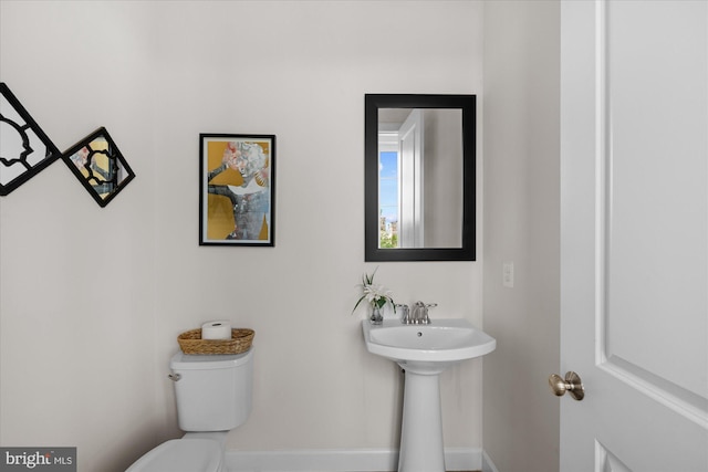 half bath with toilet and baseboards