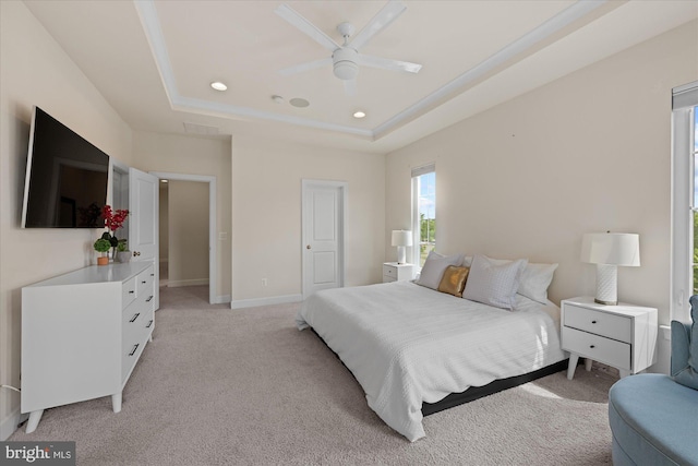 bedroom featuring light colored carpet, multiple windows, a tray ceiling, and recessed lighting