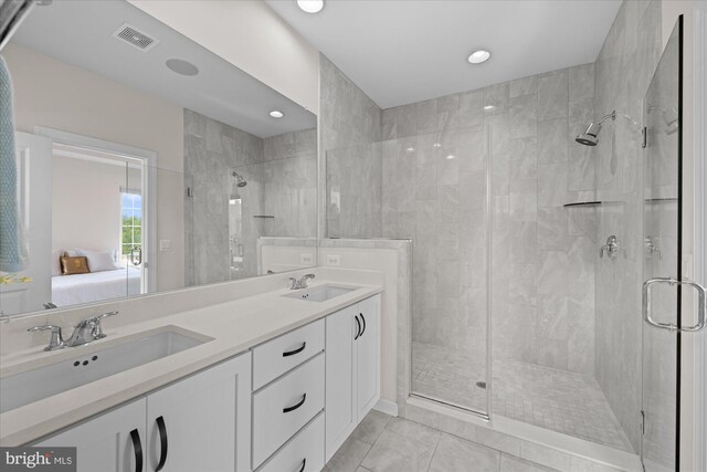 ensuite bathroom featuring a stall shower, double vanity, and recessed lighting