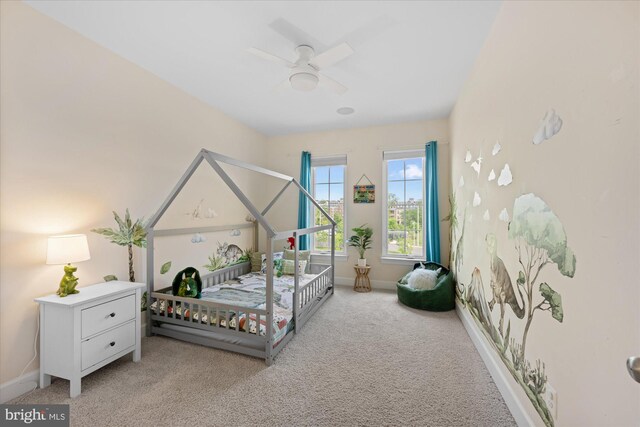 carpeted bedroom featuring baseboards and a ceiling fan