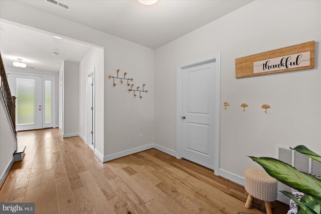 corridor with light wood finished floors and baseboards