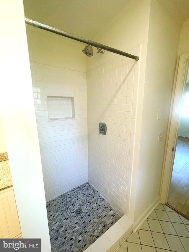 bathroom featuring baseboards, tile patterned flooring, and a stall shower