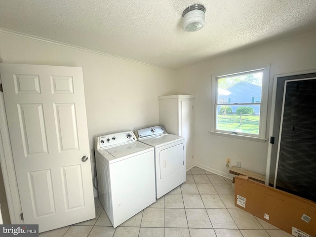 laundry area featuring light tile patterned flooring, a textured ceiling, laundry area, and separate washer and dryer
