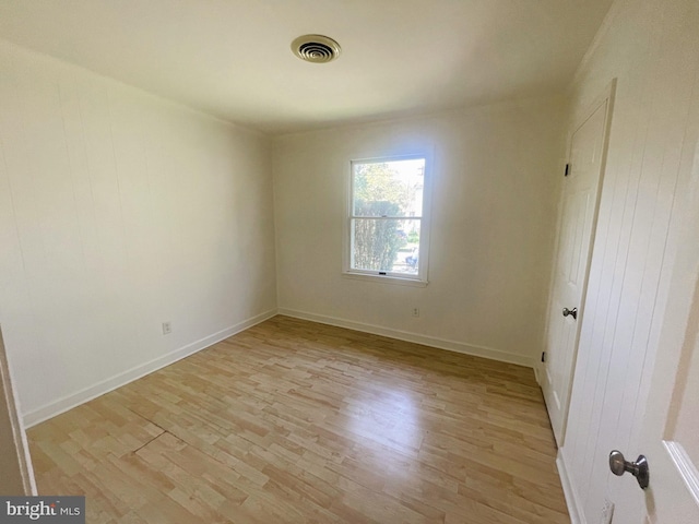 unfurnished room with light wood-style flooring, visible vents, and baseboards