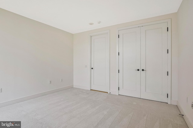 unfurnished bedroom with baseboards and light colored carpet