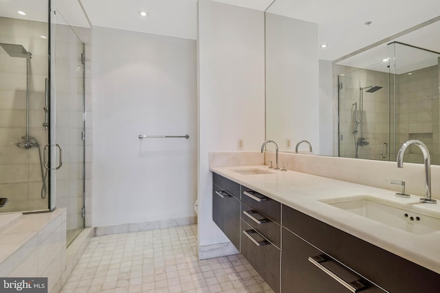 full bathroom with double vanity, toilet, a sink, and a stall shower