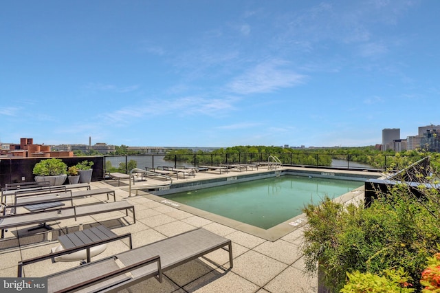 pool featuring a view of city, a patio area, and fence