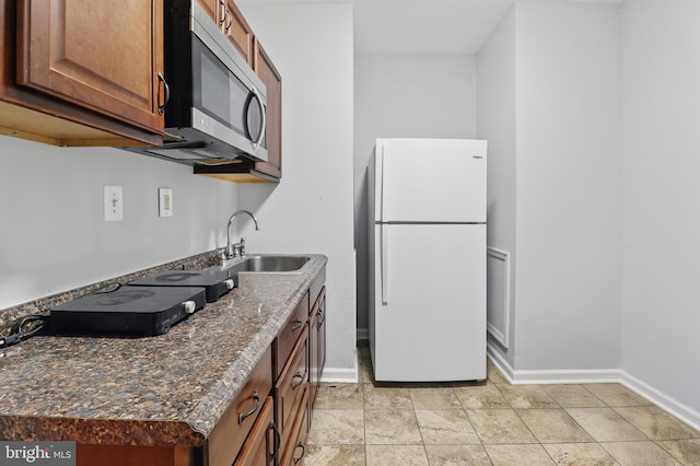 42827 Freedom St, Chantilly, VA 20152 - kitchen with freestanding refrigerator, stainless steel microwave, baseboards, a sink, and brown cabinets