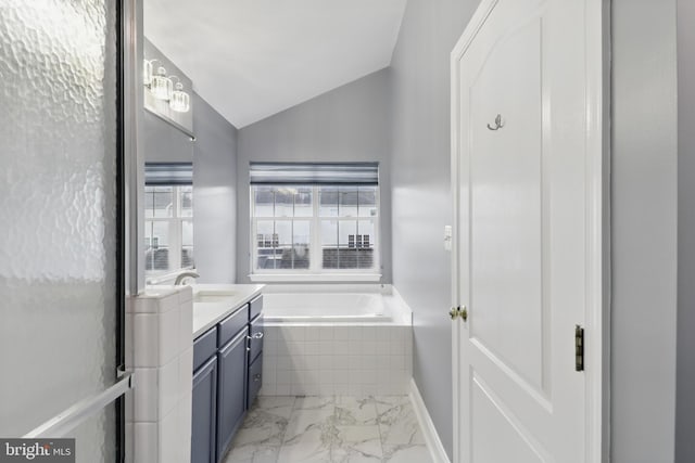 42827 Freedom St, Chantilly, VA 20152 - bathroom featuring a garden tub, vanity, vaulted ceiling, and marble look tiles