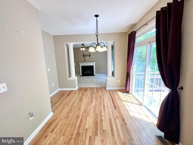 388 Wood Landing Rd, Fredericksburg, VA 22405 - unfurnished dining area with light wood-style floors, decorative columns, baseboards, and a fireplace